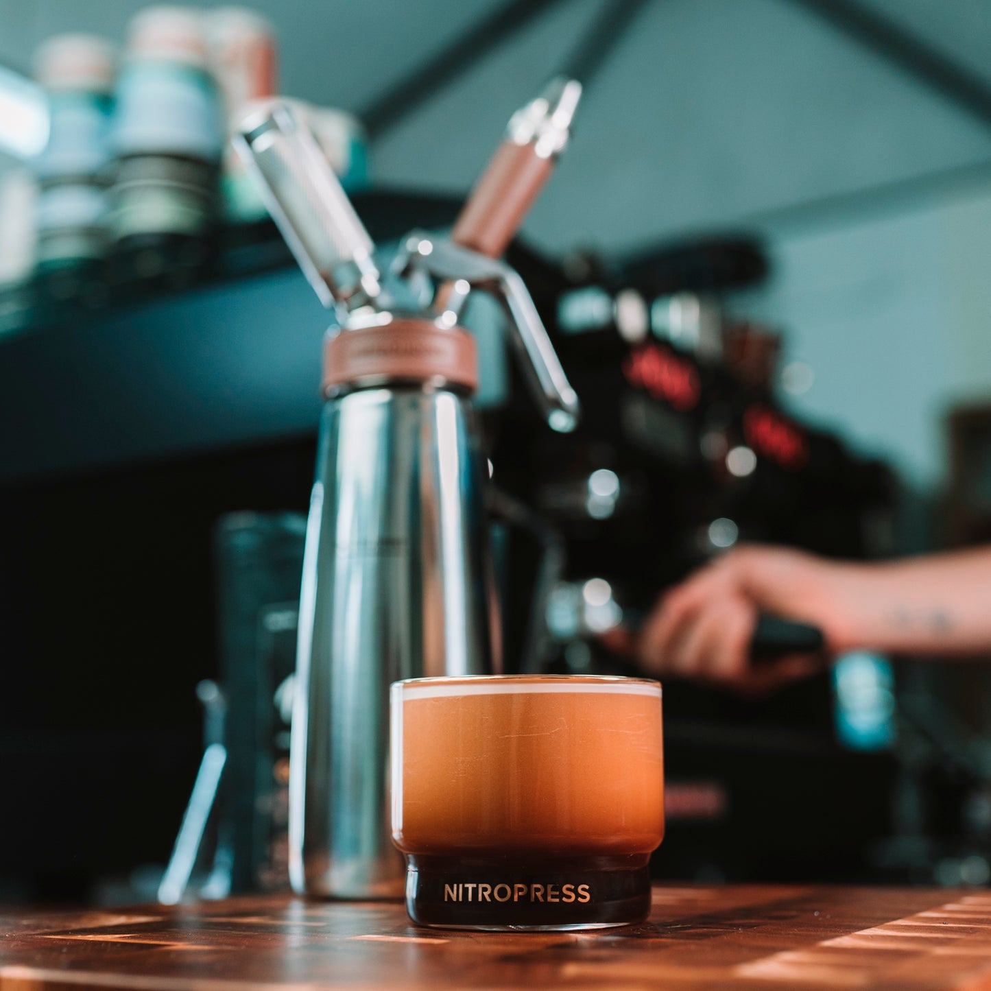 Hero shot of nitro press with barista in the background